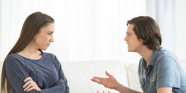 Young man explaining woman while arguing in living room