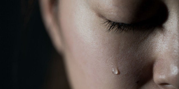 Young woman crying with tear drop.