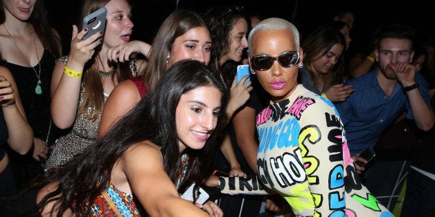 EDS NOTE: LANGUARGE - Amber Rose, right, takes a photo with a fan as she arrives at the MTV Video Music Awards at the Microso