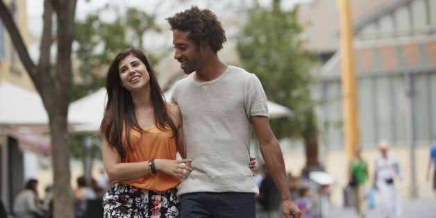 Loving young couple walking together in city