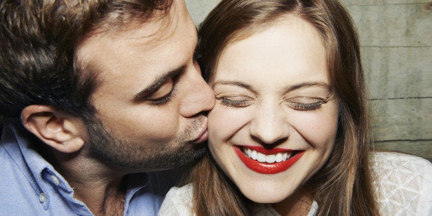 man kissing woman on cheek