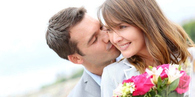 Portrait of romantic man giving flowers to woman