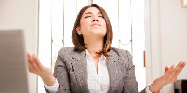 Beautiful Hispanic business woman relaxing and doing some meditation at her office