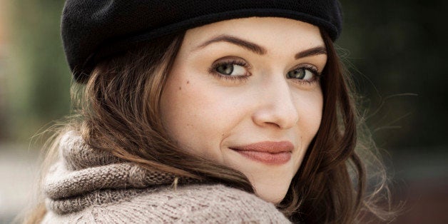 Portrait of smiling young woman wearing beret and knitted dress