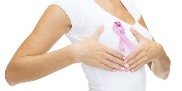 healthcare and medicine concept - woman in blank t-shirt with pink breast cancer awareness ribbon checking breast