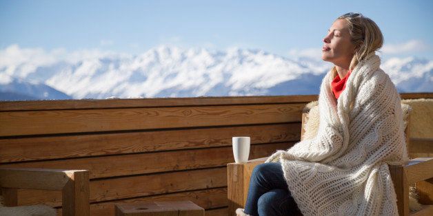 Woman day dreaming at the terrace of a hotel, Crans-Montana, Swiss Alps, Switzerland
