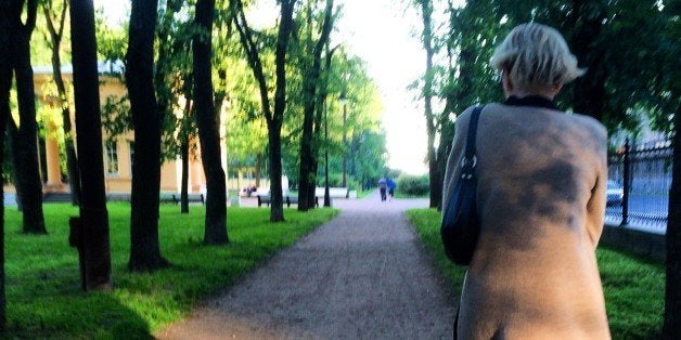 Rear View Of Woman Walking On Footpath Amidst Trees