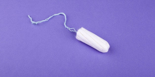 Single tampon on purple surface