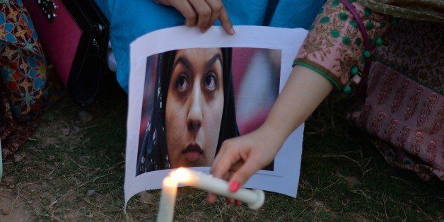 Activists of Civic Face Pakistan hold a photograph of Reyhaneh Jabbari, who was hanged in Iran for murdering a former intelligence officer Jabbari claimed had tried to sexually assault her, during a candle vigil in her memory in Islamabad on October 31, 2014. Iran on October 25 hanged a woman convicted of murdering a former intelligence officer she claimed had tried to sexually assault her, defying international appeals for a stay of execution. Reyhaneh Jabbari, 26, who had been on death row for five years, was put to death at dawn, the official IRNA news agency quoted the Tehran prosecutor's office as saying. AFP PHOTO/ Aamir QURESHI (Photo credit should read AAMIR QURESHI/AFP/Getty Images)