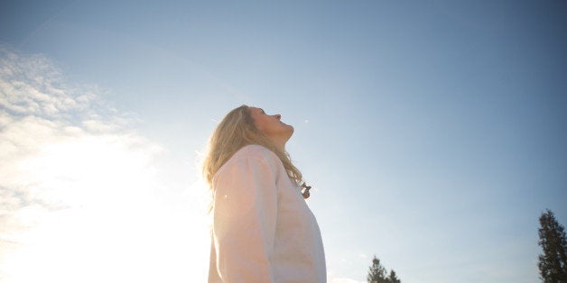 A woman looks into the sky on a sunny day.