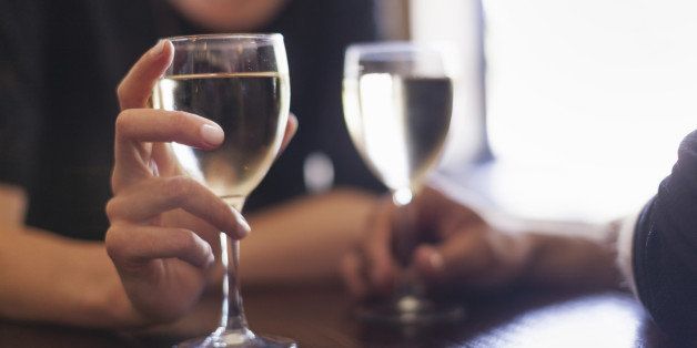 Two people, a couple sitting in a bar having a glass of chilled white wine.