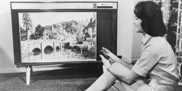 A woman watching a large RCA television.