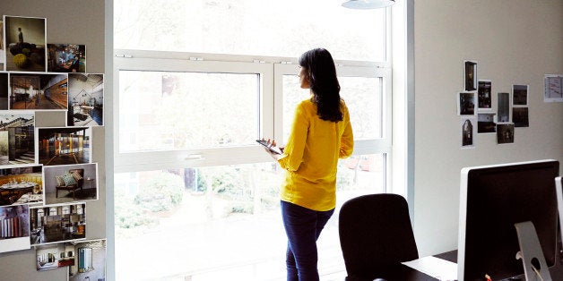 Female office worker looking out of a window.