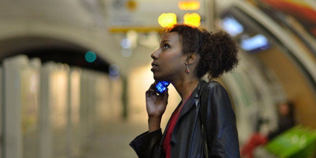 Young woman using mobile phone in a metro station