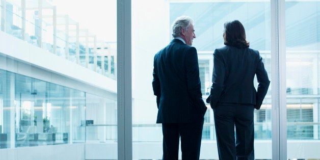 Business people talking near glass wall in office