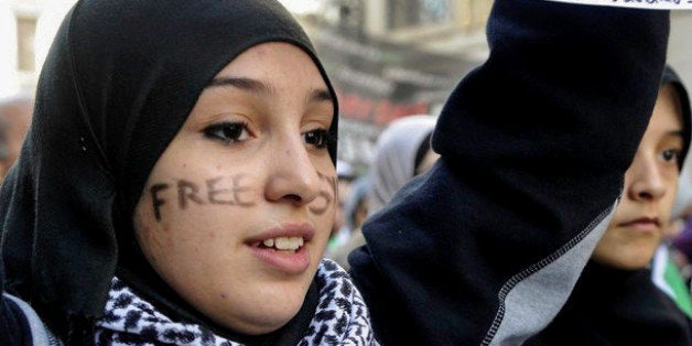 A young woman with the words "Free Syria" written on her face attends a demonstration against violence in Syria on February 26, 2012 in Madrid.