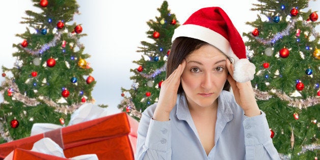 Stressed woman shopping for gifts of christmas with red santa hat looking angry and distressed