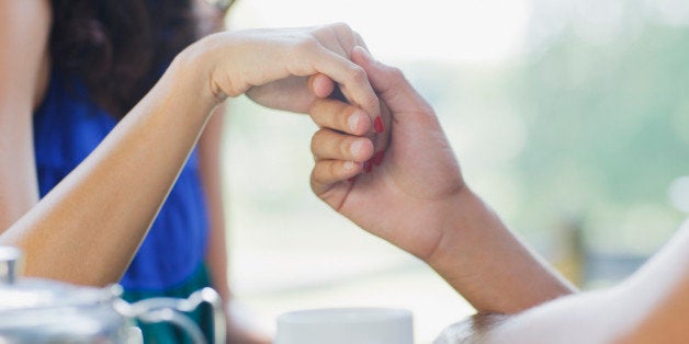 Couple having tea and holding hands