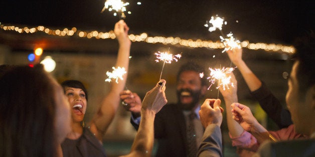 Friends playing with sparklers at party