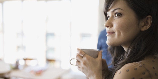 Smiling woman with coffee looking away