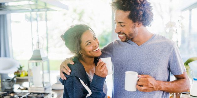 Smiling couple embracing in the kitchen in the morning