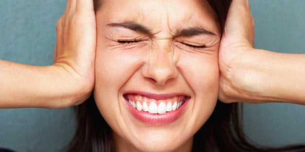 Closeup portrait of young woman covering ears with closed eyes