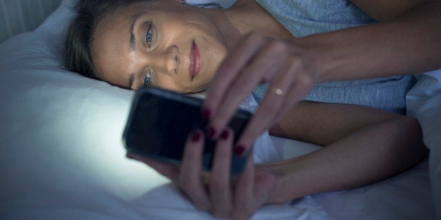 Woman in bed using smartphone