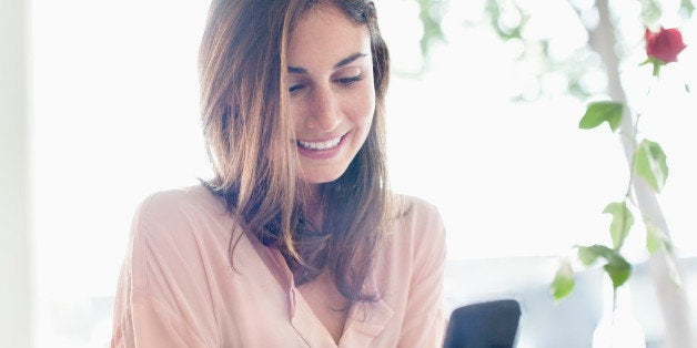 Smiling businesswoman checking cell phone