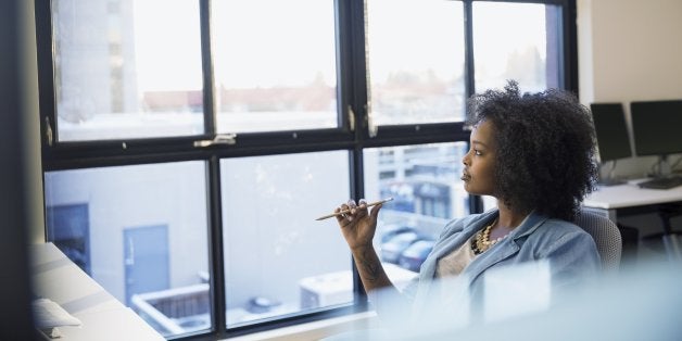 Pensive businesswoman looking out office window