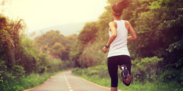 young fitness woman runner running at forest trail