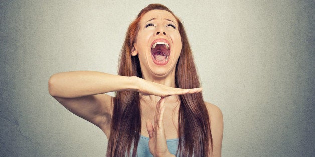 Young woman showing time out hand gesture, frustrated screaming to stop isolated on grey wall background. Too many things to do. Human emotions face expression reaction