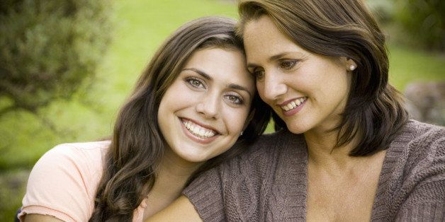 Mother and teenage daughter (16-18) hugging, portrait of daughter