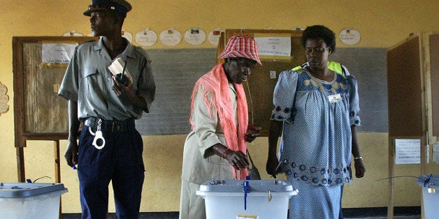 An unidentified old woman is assisted by an election official before voting in the town of Tsholotsho around 125 kilometers (78 miles) from Bulawayo, Zimbabwe Thursday, March 31, 2005. Zimbabweans waited in long lines Thursday to cast ballots in parliamentary elections that President Robert Mugabe hopes will prove once and for all the legitimacy of a regime critics say is increasingly isolated and repressive. (AP Photo/Schalk van Zuydam)