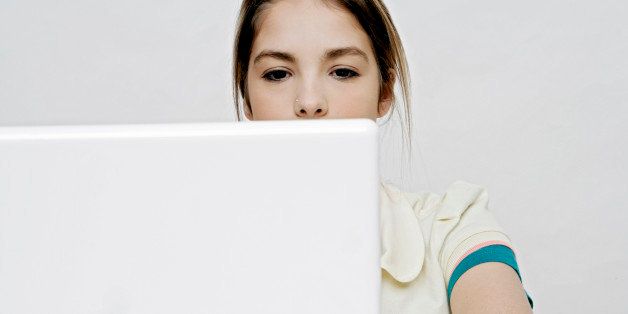View of a teenage girl working with a laptop.