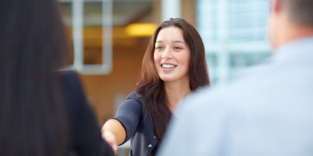 Business woman greeting partners in the meeting room