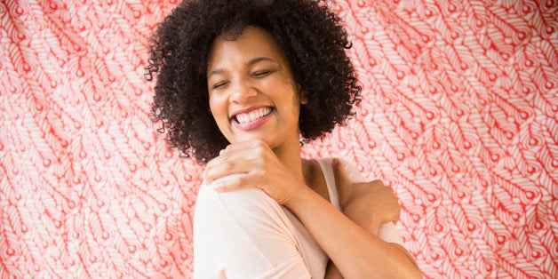 Smiling woman hugging herself