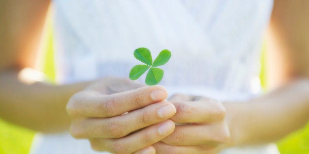 Hispanic woman holding four-leaf clover