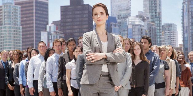 Portrait of confident businesswoman with business people in background