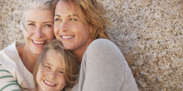 Three generations of women smiling outdoors