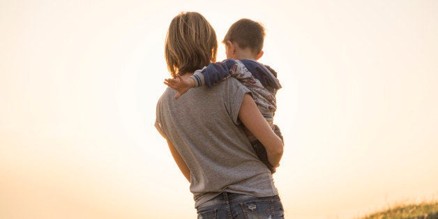 Mother holding son in rural field