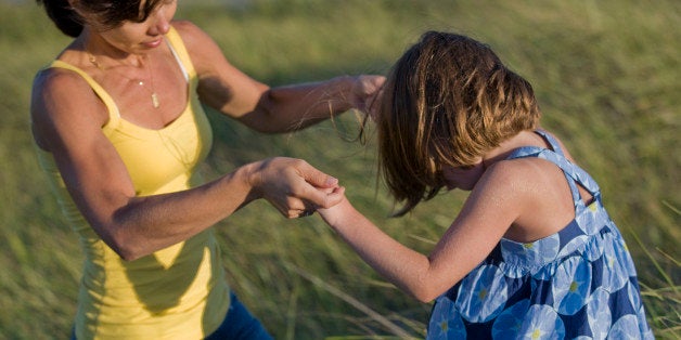 Mother holding onto daughter outdoors