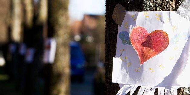 note with red heart sticking on tree