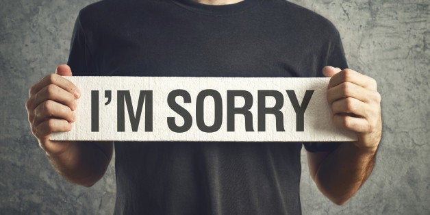 Man holding I am sorry message on white board. remorse concept.