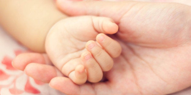 blur background hand baby on hand's mother.