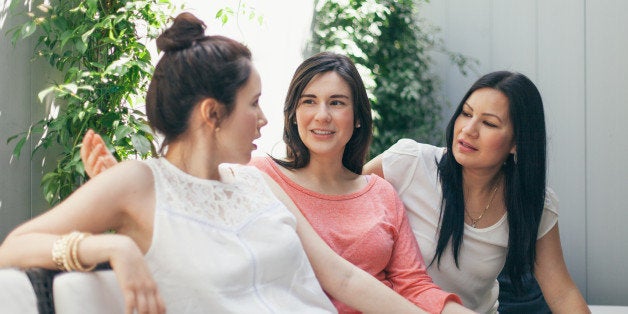 women talking together on sofa outdoor