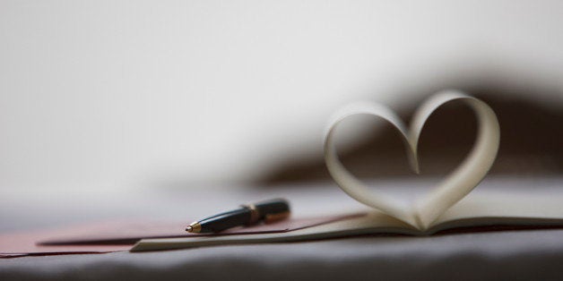 Pen and pages of notebook forming heart-shape