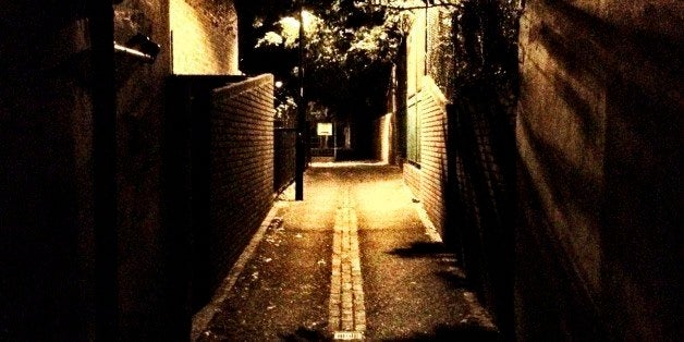 An empty and intimidating back street in North London illuminated by a single street lamp.