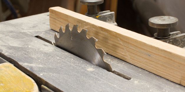 woodworking circular saw with wooden plank closeup