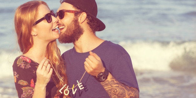 Young couple in love walking in the park holding hands looking in the sunset