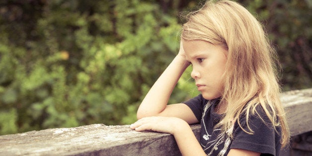 Portrait of sad blond little girl sitting on the bridge at the day timePortrait of sad blond teen girl sitting on the bridge at the day time